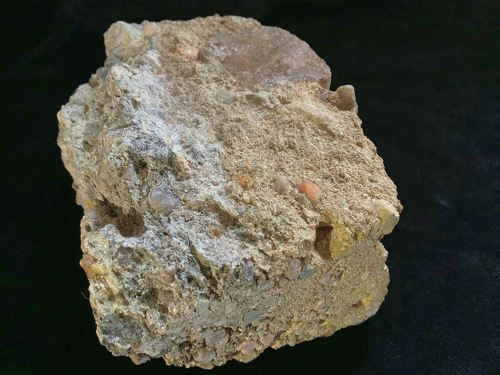 Hand specimen of conglomerate on black background